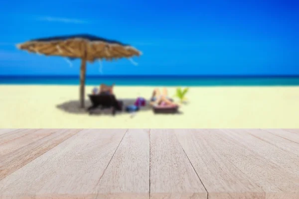 Mesa de madeira superior e borrão de fundo de praia tropical — Fotografia de Stock