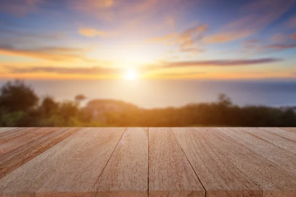 Toppa träbord och oskärpa solnedgång bakgrund — Stockfoto