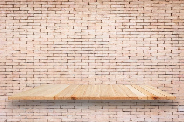 Empty wooden shelf and brick wall
