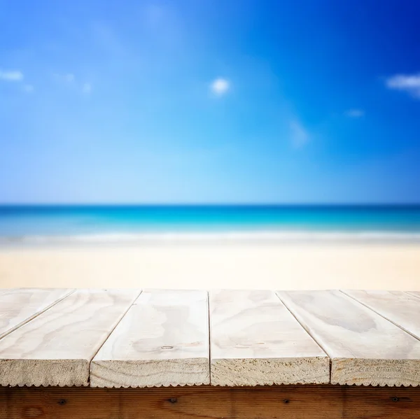 Деревянный стол и тропический пляж Лицензионные Стоковые Фото