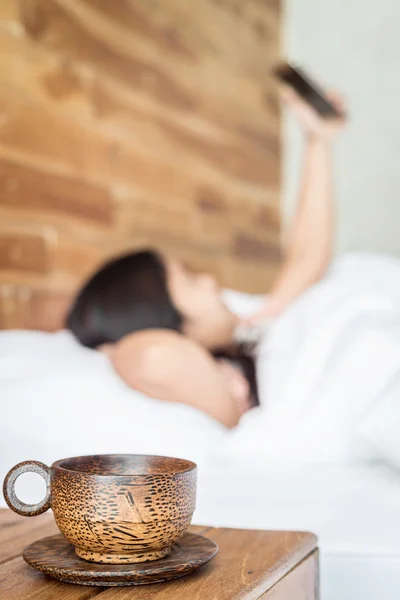 Taza de café y mujer usando teléfono inteligente — Foto de Stock