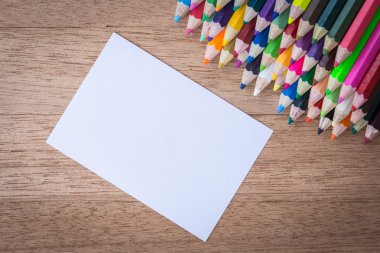 Stack colour pencils on wooden background clipart