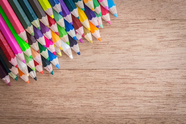 Стек кольорові олівці на дерев'яному фоні — стокове фото