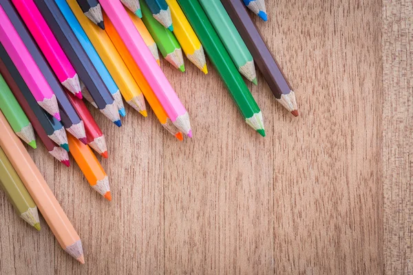Stack colour pencils on wooden background Royalty Free Stock Photos