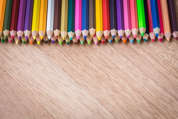 Empilhe lápis de cor no fundo de madeira Fotografias De Stock Royalty-Free