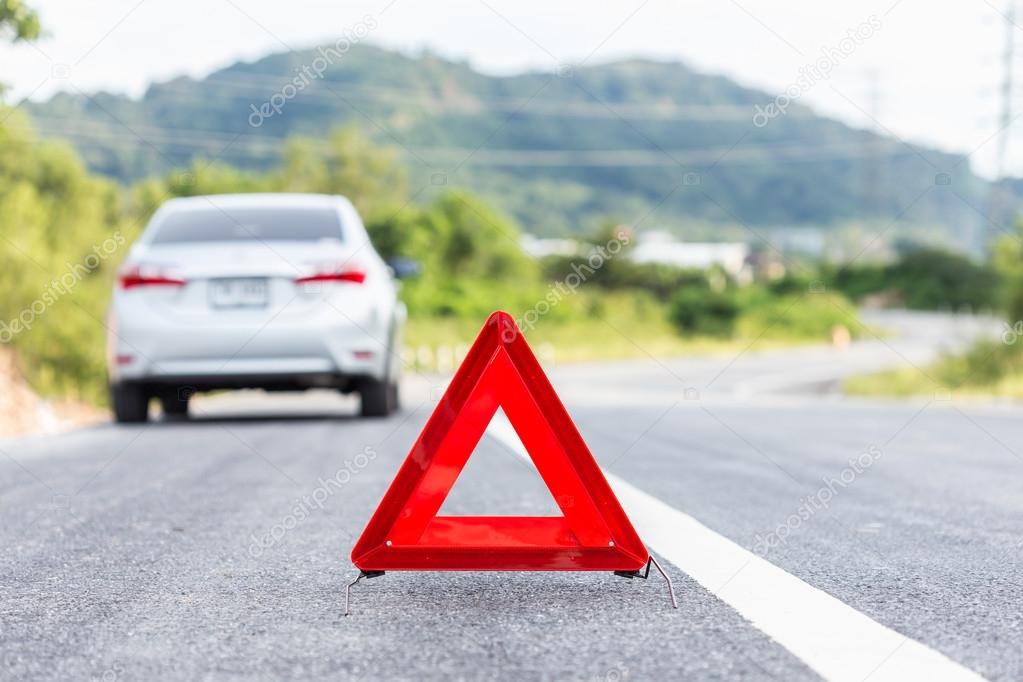 Red emergency stop sign and broken silver car