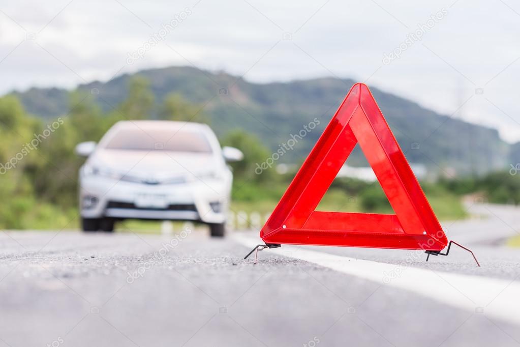 Red emergency stop sign and broken silver car