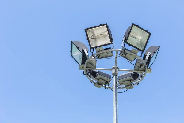 Holofotes, luzes do estádio no céu azul — Fotografia de Stock