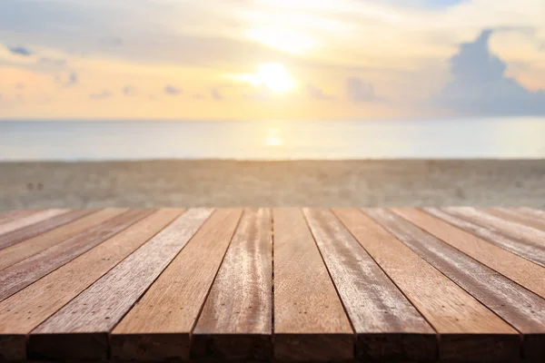 Platte eines Holztisches am Strand bei Sonnenuntergang. kann zur Produktdarstellung verwendet werden — Stockfoto