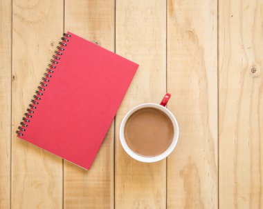 Ahşap masa üzerinde kırmızı kitap ve kahve fincanı Üstten Görünüm