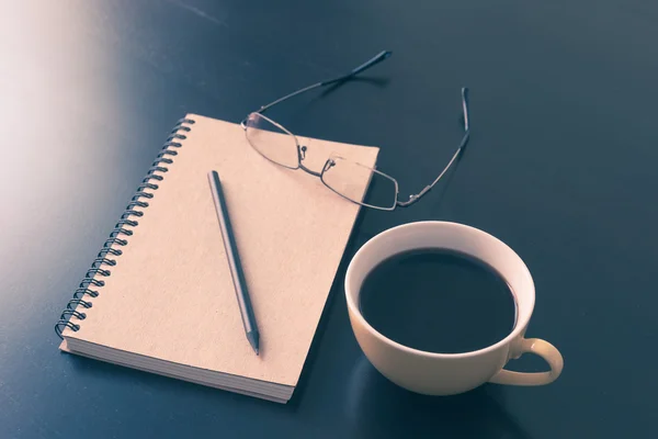 Buch und Kaffeetasse auf schwarzem Holztisch — Stockfoto