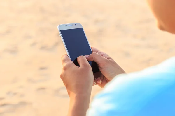 Asia kobieta korzystanie smartphone na plaży w zachód słońca, Phuket — Zdjęcie stockowe