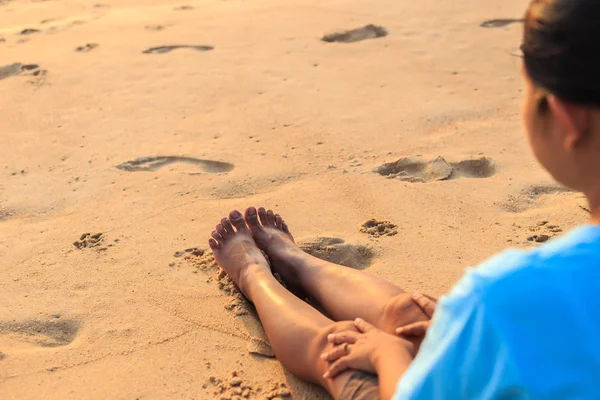 Азиатка сидит на пляже на закате — стоковое фото
