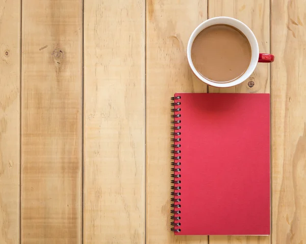 Ovansida av röda boken och kaffekopp på träbord — Stockfoto