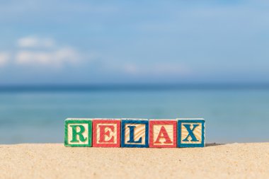 renkli alfabe bloklar tropikal plaj üzerinde Relax Word'de
