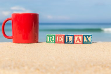 Relax word renkli alfabe blokları ve kahve fincanı tropica