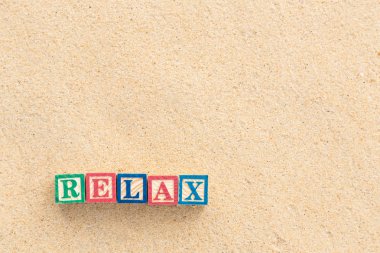 renkli alfabe bloklar tropikal plaj üzerinde Relax Word'de