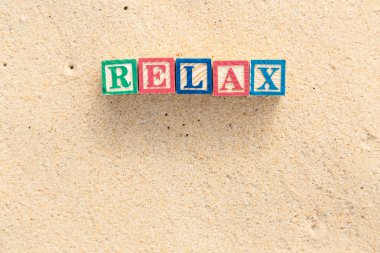 renkli alfabe bloklar tropikal plaj üzerinde Relax Word'de