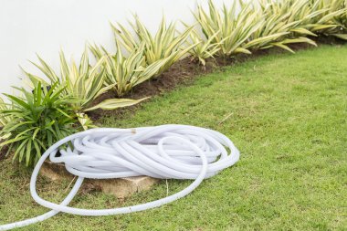 Plastik su hortumu bahçede rulo