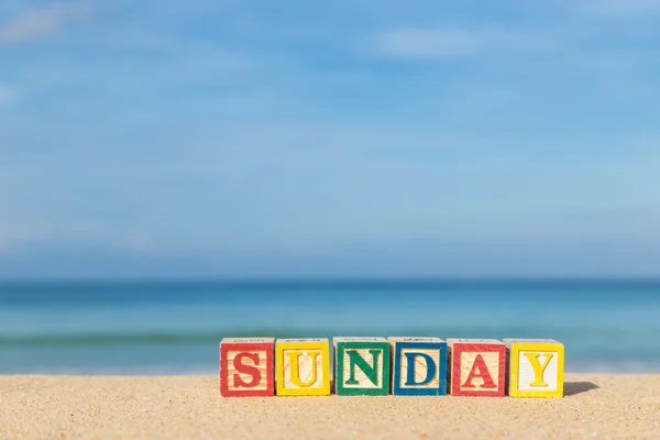 Word SUNDAY in colorful alphabet blocks on tropical beach — Stock Photo, Image