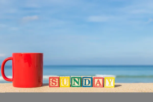 Слово воскресенье в красочных алфавитных блоков и чашки кофе на тропический — стоковое фото
