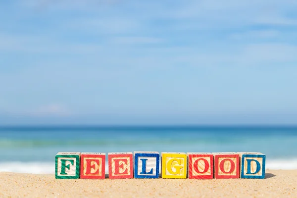 Word FEELGOOD in colorful alphabet blocks on tropical beach — Stock Photo, Image