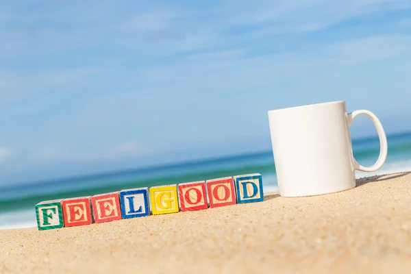 Parola FEELGOOD in blocchi di alfabeto colorato sulla spiaggia tropicale — Foto Stock