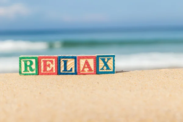 Ordet Relax i färgglada alfabetet block på tropical beach — Stockfoto