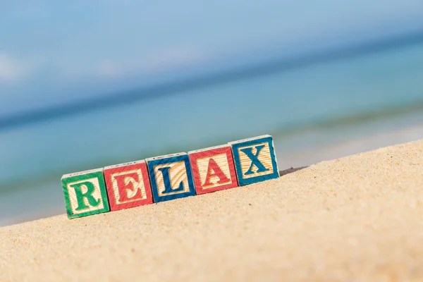 Ordet Relax i färgglada alfabetet block på tropical beach — Stockfoto