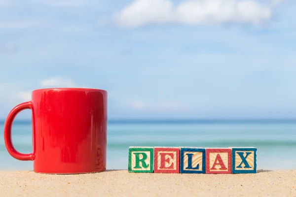 Word RELAX in colorful alphabet blocks and coffee cup on tropica — Stock Photo, Image