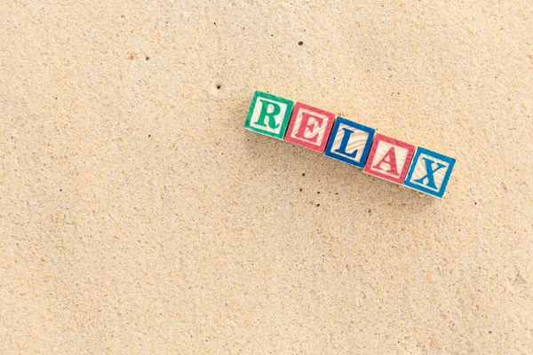 Palabra RELAX en bloques de alfabeto de colores en la playa tropical —  Fotos de Stock