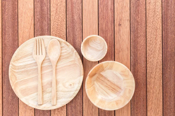 Puste naczynia drewniane, widelec, łyżka i miski na drewnianym stole — Zdjęcie stockowe