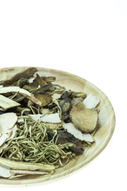 Mix of chinese herbal medicine in wooden dish isolated on white  clipart