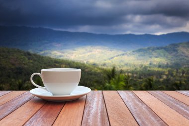 Ahşap masa ve doğa arka plan bakış beyaz kahve fincanı 