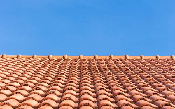 Rote Ziegel Dach und blauer Himmel Hintergrund — Stockfoto