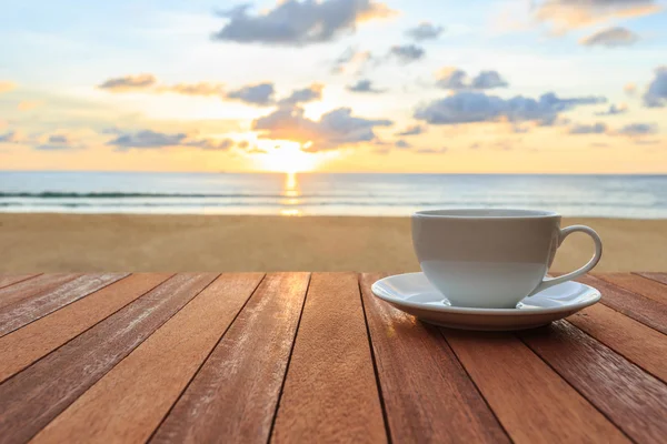 Vit kaffekopp på bord av trä och utsikt över solnedgången eller sunrise bac — Stockfoto