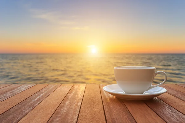 Tasse à café blanche sur table en bois et vue sur le coucher ou le lever du soleil bac — Photo