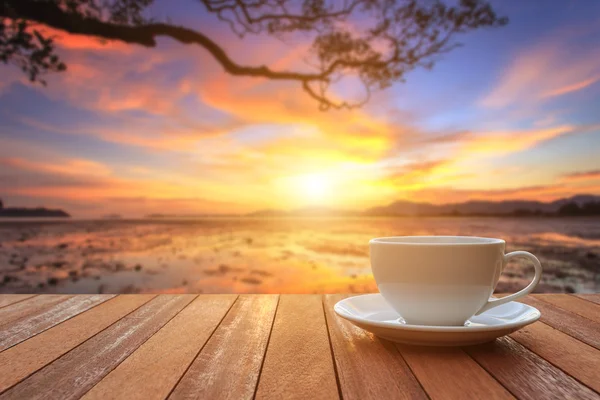 Tasse à café blanche sur table en bois et vue sur le coucher ou le lever du soleil bac — Photo