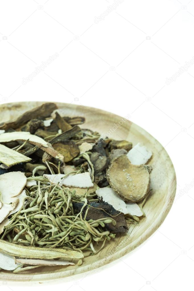 Mix of chinese herbal medicine in wooden dish isolated on white 