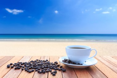 Beyaz kahve fincanı ve ahşap masa ve görünümü Güneşlerin kahve çekirdekleri