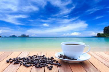 Beyaz kahve fincanı ve ahşap masa ve görünümü Güneşlerin kahve çekirdekleri