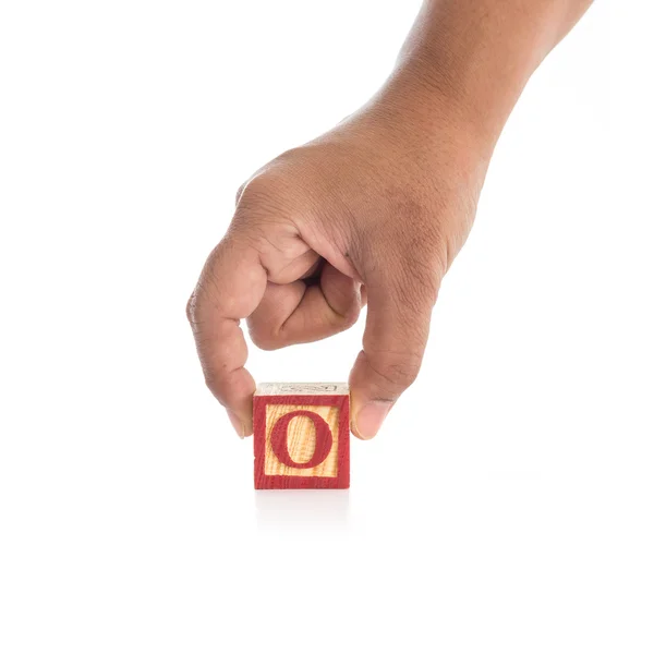 手拿着多彩的字母块"O"上白色孤立 — 图库照片