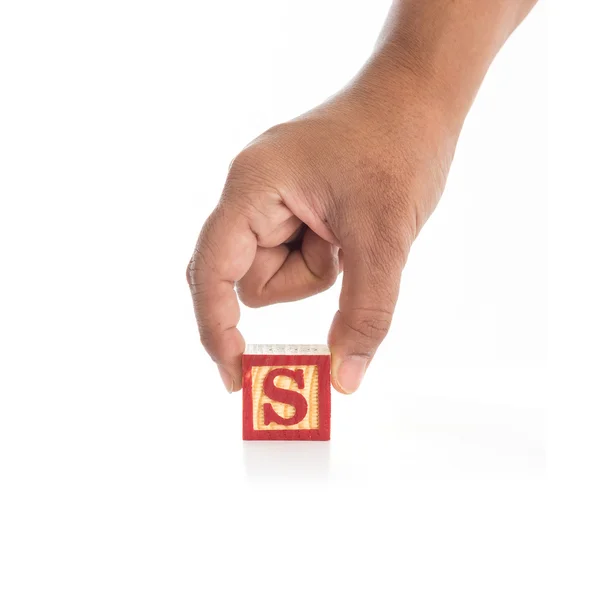 Mano sosteniendo bloques de alfabeto de colores "S" aislado en blanco — Foto de Stock