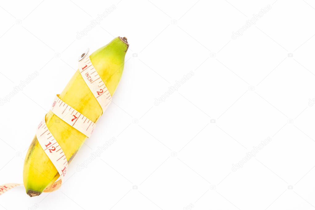 Banana and measuring tape on white background. Men penis size concept.