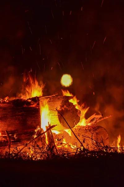 Şenlik ateşine yakın ve dolunayda Minnesota, ABD kırsalında sıcak turuncu közler var.