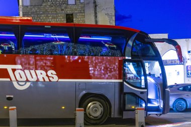 Hayfa, İsrail 12-17-2025 Kırmızı ve gri turist otobüsü İsrail 'in Hayfa kentindeki Wadi Nisnas' ta tatil süslemelerinin keyfini çıkarıyor..