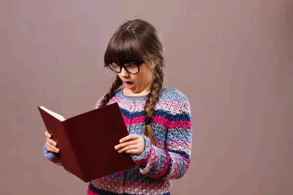 Kleine Streberin überrascht mit Buch — Stockfoto