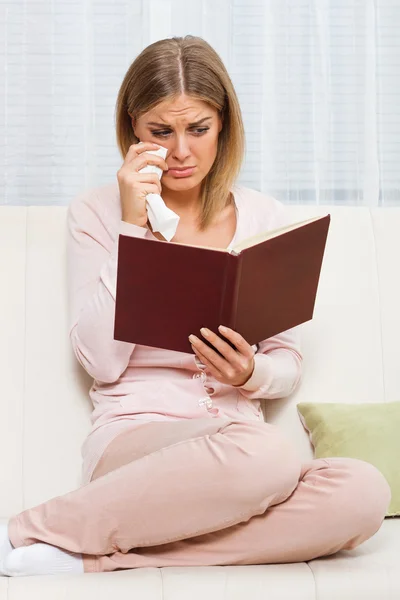 Плачущая женщина читает книгу — стоковое фото