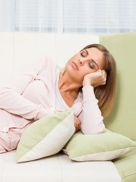 Beautiful woman is resting at sofa — Stock Photo, Image