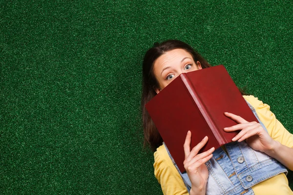 Mulher escondida atrás do livro — Fotografia de Stock